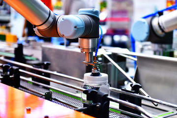 Robot arm arranged glass water bottle on Automatic industrial machinery equipment in production line factory
