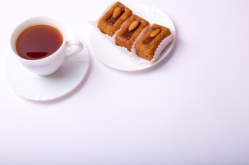 Bisquit cakes and tea cup on white background