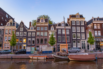 Buildings and boats along the canal at sunset time in Amsterdam, Netherlands