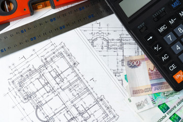 Russian roubles stack on blueprints wth calculator. Renovation, building expenses concept