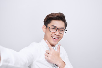 Young handsome man in the white shirt, smiling, taking pictures of themselves. Close-up