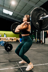 Young female weightlifter exercising in gym