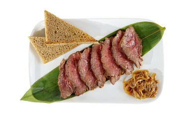 Cold appetizer before alcohol, food marinated roast beef, fried, beef, with pickled onions and bread, slices, 7 pieces on a banana leaf, on square plate, white isolated background view from above