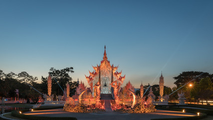 Night light in Wat Rong Khun Temple with beautiful sculptures, famous white temple in Chiang Rai, Thailand