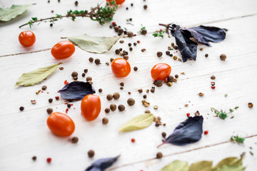 The texture of the condiments scattered on the wooden white table pepper, Basil, Bay leaf