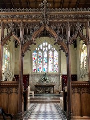 church interior with carved wooden structure and stained glass windows