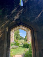 english country garden, secret garden through an archway on castle grounds