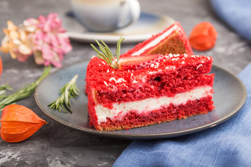 Homemade red velvet cake with milk cream and strawberry  with cup of coffee on a black concrete background. side view, selective focus.