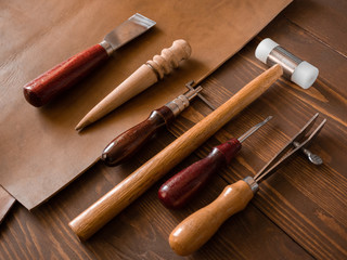Fototapeta premium Genuine Leather. Sewing a purse. Leather work. Tools for sewing bags, wallets, clutches. Stitching. Manual sewing of the product. The manufacture of leather products. 