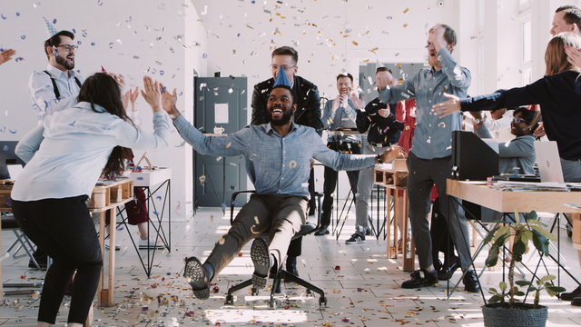 RED EPIC-W Happy young black businessman celebrating birthday at office workplace party with confetti slow motion.