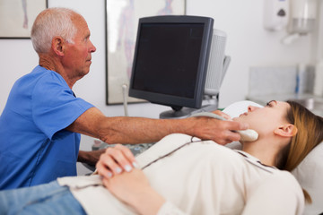 Obraz premium Woman patient undergoing examination thyroid lying by man doctor