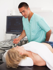 Man examination woman at abdomen with ultrasonography device