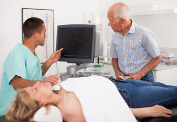 Young man doctor talking with man and  his wife