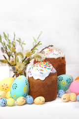 Fototapeta na wymiar Easter cakes (orthodox kulich), colorful eggs and willow twigs. Easter holiday traditional scene. 