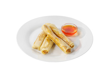Hot appetizer stuffed pancake on plate with hot red sauce, pepper, fried in oil before alcohol, white isolated background, side view