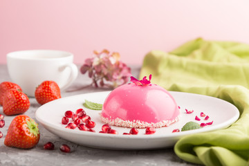 Pink mousse cake with strawberry  and a cup of coffee on a gray concrete background. side view, selective focus.