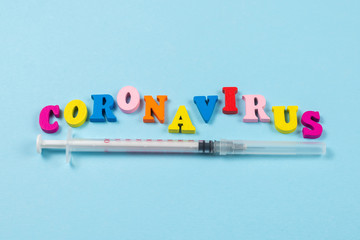 Word Coronavirus written on blue background.  Top view.