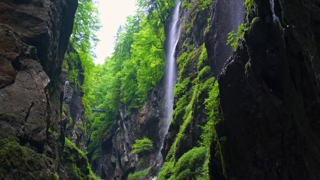 A waterfall between steep mountains with water drops falling from on high