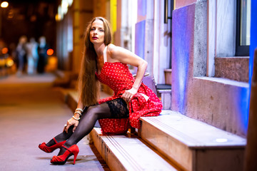 A mature woman sitting on the stairs at night