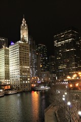 Obraz premium Night View of Chicago River with Illuminated Skyscrapers and Reflections