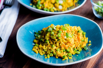 Cauliflower rice is a low calorie healthy substitute for grains of actual rice. Cauliflower rice seasoned with a mix of spices and tossed with olive oil lemon juice and garnished with scallions.