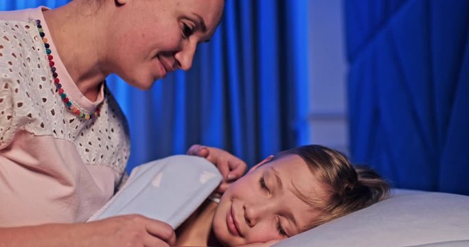 Slow motion footage  - Mama kisses and pats the sleeping child's head. Kid with his mother before going to bed. Mother puts the child to sleep sitting on the bed. Happy mom at crib of her son