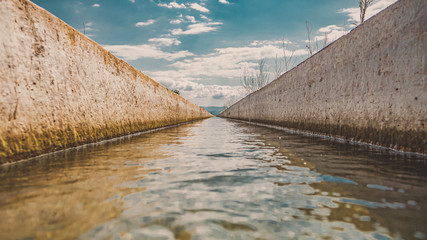long line of straight canal with water