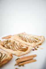 Crunchy puff pastry pie. Homemade baked pie with pears. Top view. Delicious dessert with sliced pear and chocolate powder.