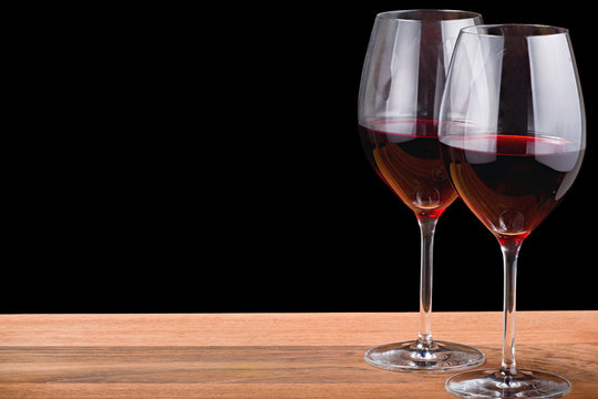 isolated two glasses with red wine on wood