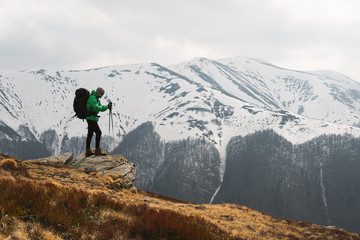 Amazing landscape with snowy mountains range and hiker with backpack on a foreground. Landscape photography