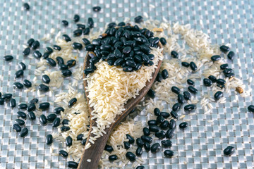 Rice and beans grains mixed on a spoon on a silver color background