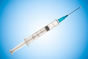 Fototapeta premium Syringe close up on blue background