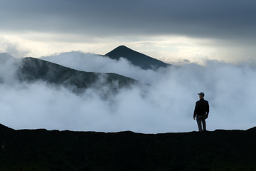 Man silhouette on cloudy mountains. Travel concept. Landscape photography