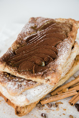 Crunchy puff pastry pie. Homemade baked pie with pears. Top view. Delicious dessert with sliced pear and chocolate powder.