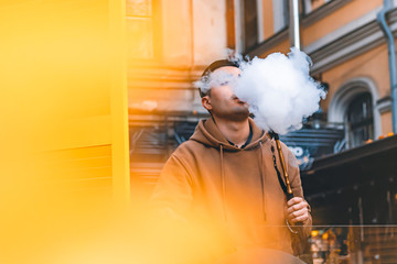 a man smoking hookah at cafe and relaxing