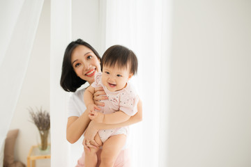 Mom and her daughter child girl are playing, smiling and hugging. Family holiday and togetherness.