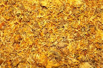 Background made of dried calendula flowers for medical use. Calendula dried flowers backdrop. 