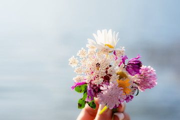 Holding bouquet of wild flowers