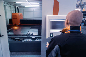 Man controls laser cutting of metal