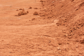 Flat red hard soil and dirt fragments closeup