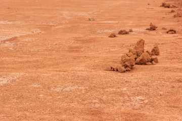 Flat red hard soil and dirt fragments closeup