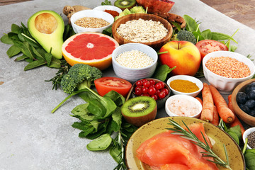 Healthy food clean eating selection: fish, fruit, vegetable, cereal, leaf vegetable on rustic background