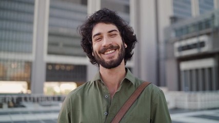Portrait of a smiling young professional man standing in front of corporate building looking at camera - Powered by Adobe