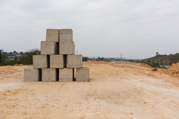 Heavy stone pier stacked on dirt road at construction site