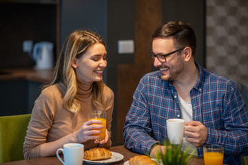 Happy couple enjoying their breakfast together at home