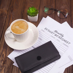 Wallet with money and cards on a wooden table. Personal finance, savings and investing concept.