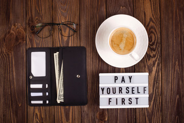 Wallet with money and cards on a wooden table. Personal finance, savings and investing concept.