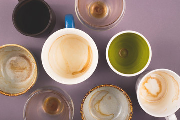 Several empty cups of coffee viewed from above on gray table. Top view layout.
