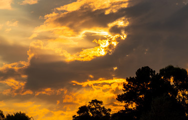 Silhouette of sunset and clouds in a farm area in Brazil