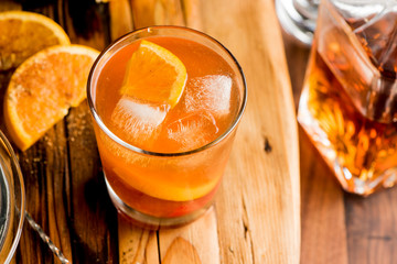 Old fashioned, Manhattan cocktail. Classic American drink favorite made w/ rye whiskey or bourbon & muddled maraschino cherries, oranges & sugar. Served on ice garnished w/ orange peel, cherry.
